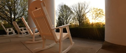 white rocking chairs on the porch of Old 鶹ƵAPP at sunrise